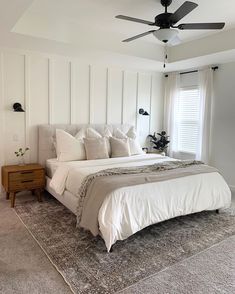 a bedroom with white walls and carpeted flooring has a large bed in the middle