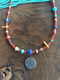 "This cheery, colorful strand of little semiprecious stones, corals and antique African Trade beads is 18 inches long. The semiprecious stones are lapis lazuli, 1 rare gaspeite, green turquoise, blue turquoise. A necklaces similar to this one was called \"Confetti\" in that famous Utah based catalog owned by Robert Redford. There are 3 tiny African Trade Beads, Venetian Stripes - each one 100-200 years old. The center bead is a gorgeous high quality lapis lazuli barrel bead. Sterling Silver lobs Adjustable Southwestern Round Necklace, Vintage Turquoise Necklace With Polished Beads, Vintage Turquoise Necklace With Polished Beads For Gift, Southwestern Style Round Beads Jewelry For Festival, Southwestern Style Jewelry With Round Beads For Festival, Bohemian Single Strand Round Jewelry, Blue Southwestern Jewelry With Colorful Beads, Artisan Sterling Silver Necklace With Polished Beads, Multicolor Hand-strung Pendant Jewelry