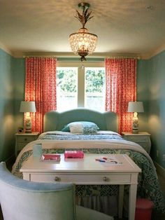 a bed room with a neatly made bed next to a table and two chairs in front of a window