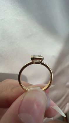 a person is holding an engagement ring with a diamond on the top and bottom part