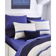 a bed with blue and white sheets and pillows