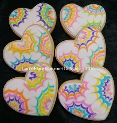 decorated cookies in the shape of hearts on a black background