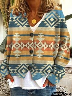 a woman standing in front of a mirror wearing a blue and yellow cardigan sweater