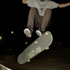 a skateboarder is doing a trick in the air at night with his board