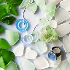 some sea glass and rings are laying on the ground