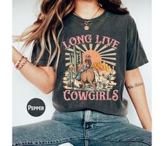 Comfort Colors Long Live Cowgirls Shirt, Western Graphic Tee, Retro Shirt, Rodeo Shirt, Cowgirl Shirt, Western Shirt, Country Girl Shirt WARNING -READ BEFORE ORDERING- REMEMBER: - The design is a Direct-to-Film (DTF) print. -You may refer to the size chart for precise measurements as all our sizes are unisex. There may be differences in sizes among brands. -Feel free to contact us if you have any issues about the things (sizes, shirt colors, design text colors, etc.). -Please be aware that we us Country Girl Shirts, Western Graphic Tees, Country Music Shirts, Rodeo Shirts, Rodeo Fashion, Cowgirl Shirts, Cow Girl, Retro Shirts, Long Live