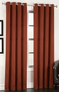 a living room with a chair and red curtains