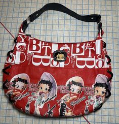 Add a pop of color and a touch of vintage style to your wardrobe with this Betty Boop shoulder bag. The oval shape and multicolor exterior make it perfect for travel, weddings, parties, or casual outings. The bag features a zip closure, studded accents, and embroidered details, along with a bag charm for added flair. Very cool item here, purchased in Europe (US version has US cities) so it's exclusive. Strap, pockets, lining and lacing on sides are in great condition. Exterior could use a wipe d Betty Boop Bag, Digital Closet, Fire Fits, Vintage Purses, Embroidered Details, Pretty Bags, Black Leather Bags, Cute Bags, Womens Purses