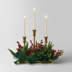 a candle holder with three candles on it and evergreens in the center, surrounded by red berries