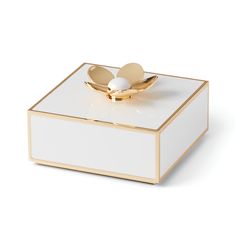 a white and gold box with two hearts on the top, sitting on a white surface