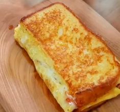 a grilled cheese sandwich sitting on top of a wooden cutting board