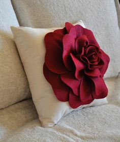 a red rose is sitting on the back of a white couch with text overlaying it