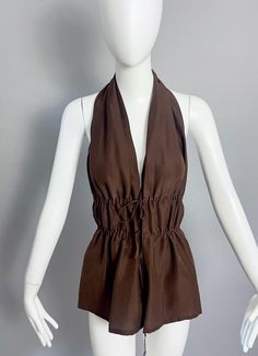 Features: - 100% Authentic JEAN PAUL GAULTIER. - Silk dark brown halter top blouse with backless feature. - Button closure and double drawstring at the front. - Label reads: JEAN PAUL GAULTIER MAILLE FEMME, Size I42 D38 F38 GB10 USA8. - Fabric composition: 100% Silk - Excellent vintage condition. Measurements taken laid flat, please double bust and waist: Bust: 16.14 inches (41 cm)  Waist: 16.53 inches (42 cm)  Length: 27.16 inches (69 cm) **This top blouse will be shipped via DHL Express Shippi Chic Brown Halter Neck Top, Sleeveless Top With Drawstring Tie For Vacation, Brown Sleeveless Top For Vacation, Beach Top With Drawstring, Chic Beach Tops With Drawstring Tie, Fitted Brown Tops For Vacation, Spring Halter Neck Top With Drawstring, Solid Halter Neck Top For Day Out, Brown Sleeveless Halter Top For Spring