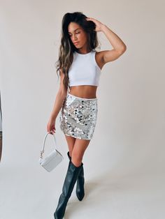 DETAILS: Our Gia Glitzy Mini Skirt is so FUN and will make a statement anywhere you wear it! This skirt features large layered silver sequins all throughout. This skirt is fully lined on the inside and has a side zipper and hook closure. This skirt has a fixed waistline, if in between sizes, we recommend sizing up. CONTENT & CARE: 95% Polyester, 5% Spandex. SIZE & FIT: Model is 5'5" The model is wearing a size Small. Fits true to size The Fabric has stretch Silver Skirts, Custom Jacket, Silver Sequin, Pop Up Shop, Concert Outfit, Wear It, Two Pieces, Side Zipper, Mini Skirt