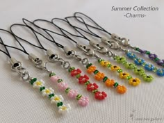 a bunch of different colored beads are on a white surface with the words summer collection charms