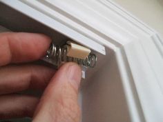 a person is opening the side of a door with two screws on each end