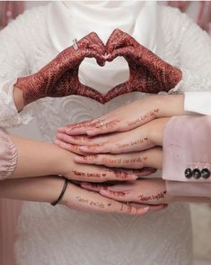 two brides holding their hands in the shape of a heart