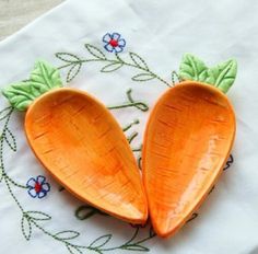 two carrot shaped dishes sitting on top of a table