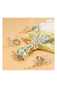 an assortment of wedding accessories including rings, bracelets and brooches on a beige background