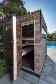 an outdoor sauna with two boats in it and the door opened to reveal a swimming pool