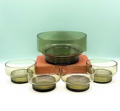 four glass bowls and three plates on a table