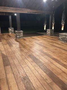 an empty wooden floor with lights shining on the top and side walls in the background