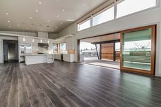 an empty living room with wood floors and sliding glass doors