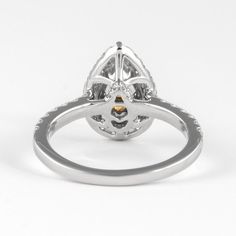 a white gold and diamond ring with an oval center stone surrounded by small round diamonds