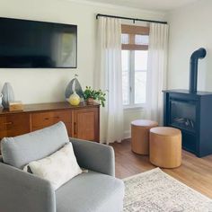 a living room with furniture and a flat screen tv mounted on the wall above a fireplace