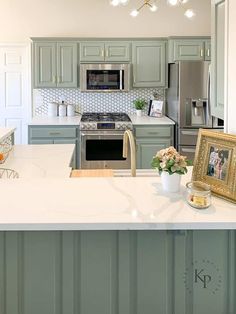 a kitchen with green cabinets and white counter tops