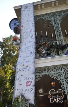 a large white banner hanging from the side of a building with lots of writing on it