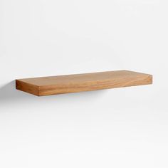 a wooden shelf against a white wall with no one on it or in front of it