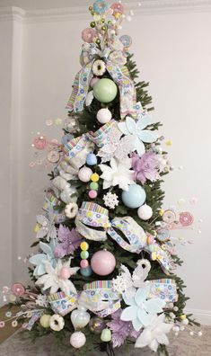 a decorated christmas tree in the corner of a room with white and blue decorations on it