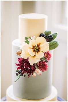 a wedding cake with flowers and berries on top