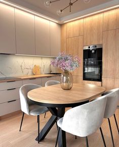 a kitchen with a table, chairs and an oven in the backround area