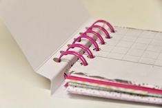 an open notebook with pink spirals on it