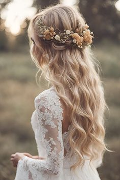 a woman with long blonde hair and flowers in her hair, wearing a white dress