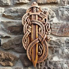 an intricately carved wooden wall hanging on a stone wall