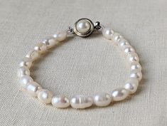 "A beautiful vintage bracelet made of strung white pearls with a lovely round clasp. There are natural imperfections in some of the pearls. Please look at all the pictures because they are part of the description. Thank you! It measures 8\" in length." Elegant Adjustable Hand-strung Pearl Necklace, Pearl White Single Strand Bracelet With Round Beads, Classic Pearl Drop Bracelet For Wedding, Beaded Pearl White Round Bracelet, Pearl White Beaded Round Pearl Bracelet, Single Strand Round Beads Pearl Bracelet, Single Strand Pearl Bracelet, Classic Wedding Pearl Drop Bracelet, Hand-strung White Bracelets For Wedding