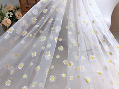 white and yellow flowers are on the sheer fabric