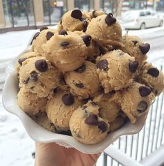 a bowl filled with chocolate chip cookies on top of a table