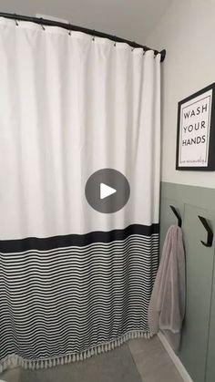 a bathroom with a white shower curtain and black and white striped shower curtain, next to a toilet