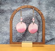 Beautiful, handmade, enamel round shape dangle earrings with stainless-steel wires. White and pink enamel combine nicely to create exquisite earrings! Gorgeous pink and white glass beads add to the earrings charm! Stainless-steel fishhook ear wires make these earrings hypoallergenic.  Handmade in Juneau, Alaska by a lifelong Alaskan.  Designed using a copper base, lead-free enamel powder is used to carefully coat both sides, heating the piece until the enamel formed a smooth, glass surface. Once fired, the enamel creates brilliant and long-lasting colors. The earrings are 26 mm in diameter. Various photographs are provided to give the buyer an idea of how the earrings look in different light.  Each piece is handmade, and you will see there are slight differences between the two earrings. T Handmade Pink Circular Earrings, Handmade Pink Circle Earrings, Pink Hand Painted Dangle Earrings, Hand Painted Pink Round Earrings, Pink Enamel Dangle Jewelry, Pink Circle Earrings For Gift, Pink Circle Earrings As A Gift, Pink Circle Earrings For Gifts, Handmade Pink Metal Earrings