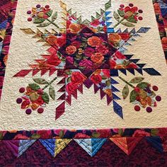 a quilted table topper with colorful flowers on it