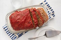 the meatloaf is sliced and ready to be served on the table with silverware