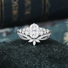 a close up view of a diamond ring on top of a black cloth with books in the background