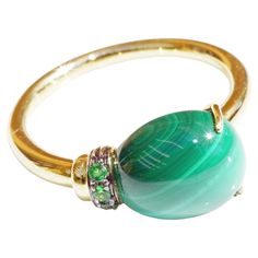 Drop ring made in a traditional Italian goldsmith in Valenza, delightful design, a malachite drop with smooth surface as if floating, held by 2 long fine crabs and an overlay set with a fine green tsavorite (green garnet), 6.75 ct and 0.04 ct, made in 750 yellow gold, dimensions of the ring approx. 21.5 x 9 x 8 mm, Rw 54 / 17.2 mm, also with matching pendant and bangle (see last pictures), all details have been checked by a jewelry appraiser for authenticity and quality About our manufacturer: We have our jewelry made in the Italian city of Valenza. There, a traditional master workshop takes care of our creations in 18 carat gold in loving small series with the best diamond qualities. In Valenza you will find the best jewelry manufacturers in Italy, e.g. Bulgari, Gucci, Pomellato, Crivelli Drop Ring, Italian City, Modernist Ring, Green Garnet, Malachite Stone, Pink Topaz, Modern Ring, Brown Diamond, Jewelry Manufacturers