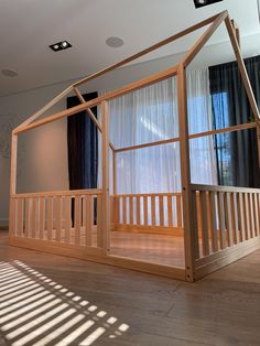 a house made out of wood and glass in the middle of a room with windows