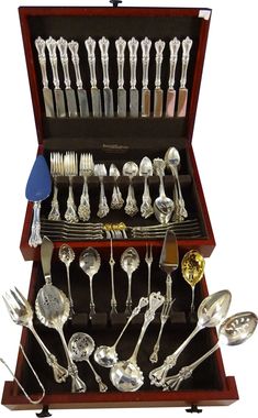 an assortment of silverware in a wooden case