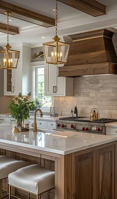 a kitchen with an island and several lights hanging from the ceiling, along with stools